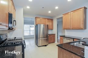 Mooresville house for rent - an empty kitchen with wooden cabinets and stainless steel appliances