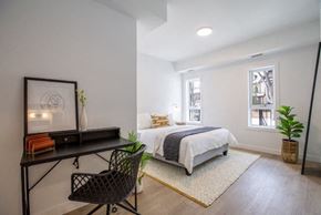 Winnipeg apartment for rent - A black chair is in front of a desk with a vase and picture frame on it.