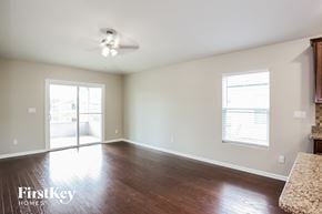 Jacksonville house for rent - A room with wooden floors and a ceiling fan.