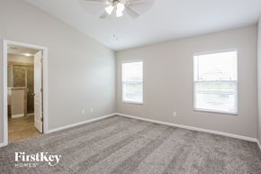 Jacksonville house for rent - A spacious room with a carpeted floor and a ceiling fan.