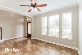Richmond house for rent - an empty living room with a ceiling fan and windows