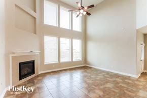 Richmond house for rent - an empty living room with a fireplace and a ceiling fan