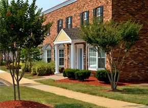 Fairfax townhouse for rent - A brick building with a porch and trees in front.