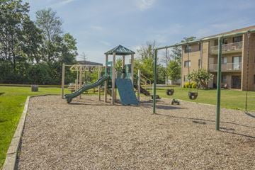 Fairfax townhouse for rent - A playground with a green slide and a wooden swing set.