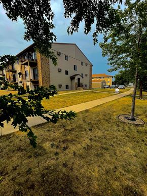 Fargo apartment for rent - a building on the side of a grass field