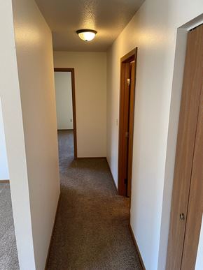 Fargo apartment for rent - a hallway with a door to a bedroom and a hall way to a bathroom and