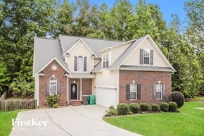 High Point house for rent - A brick house with a white garage door and a driveway.