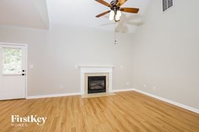 High Point house for rent - A room with a fireplace and a ceiling fan.