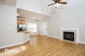 High Point house for rent - A spacious living room with a fireplace and a ceiling fan.