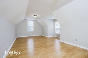 High Point house for rent - A spacious room with wooden floors and two windows.