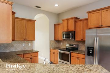 Palm Bay house for rent - a kitchen with wooden cabinets and stainless steel appliances