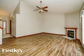 Westerville house for rent - A spacious room with a fireplace and a ceiling fan.
