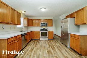 Westerville house for rent - A kitchen with wooden cabinets and a refrigerator.