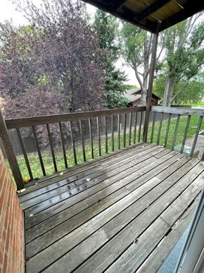Fargo apartment for rent - a backyard deck with a wooden fence and trees