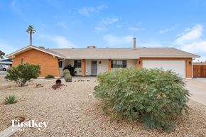 Phoenix house for rent - a house with a white garage door and a gravel driveway