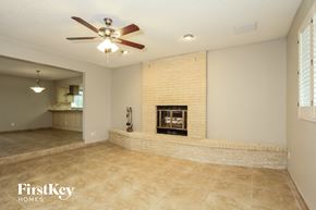 Phoenix house for rent - an empty living room with a brick fireplace and a ceiling fan