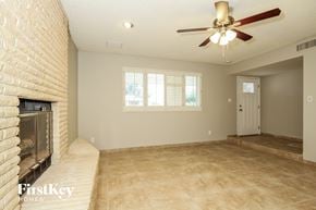 Phoenix house for rent - a living room with a fireplace and a ceiling fan