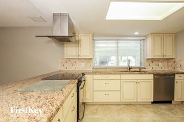 Phoenix house for rent - a kitchen with white cabinets and a granite counter top