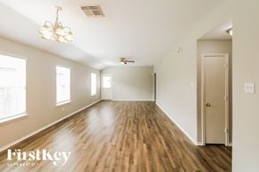 Baytown house for rent - A room with wooden floors and a chandelier hanging from the ceiling.