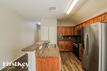 Baytown house for rent - A kitchen with wooden cabinets and a granite countertop.