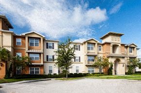 Orlando apartment for rent - A large apartment complex with a parking lot in front.