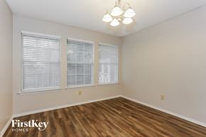 Burleson house for rent - the living room of an empty house with wood flooring and three windows