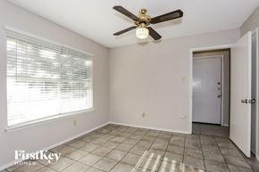 Burleson house for rent - an empty room with a ceiling fan and a window