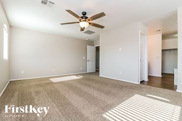 Tolleson house for rent - a living room with carpet and a ceiling fan