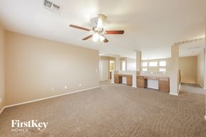 Surprise house for rent - A spacious room with a ceiling fan and beige walls.