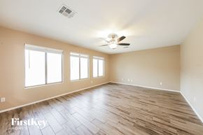 Surprise house for rent - A spacious room with wooden flooring and a ceiling fan.