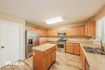 Surprise house for rent - A kitchen with wooden cabinets and a stainless steel refrigerator.