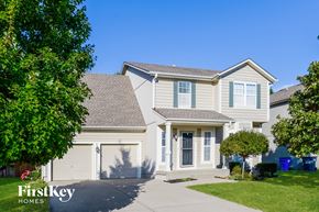 Olathe house for rent - A house with a garage and a driveway is for sale.