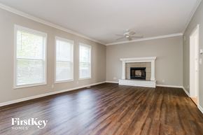 Olathe house for rent - A spacious room with a fireplace and wooden floors.