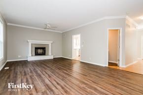 Olathe house for rent - A spacious room with a fireplace and wooden floors.