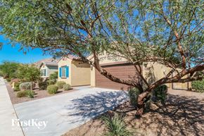 Buckeye house for rent - a house with a driveway and a tree in front of it