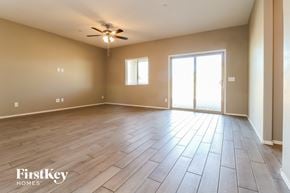 Buckeye house for rent - an empty living room with wood floors and a ceiling fan