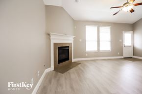 Spring house for rent - a living room with a fireplace and a ceiling fan