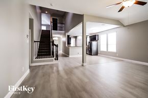Spring house for rent - an empty living room with a staircase and a ceiling fan