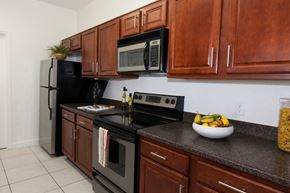 Orlando apartment for rent - a kitchen with stainless steel appliances and wooden cabinets