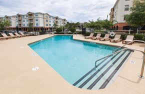 Orlando apartment for rent - a resort style pool with lounge chairs and a building in the background