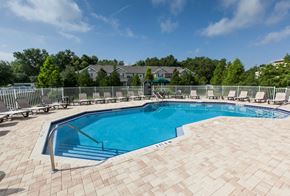 Lady Lake apartment for rent - a resort style pool with chairs and a fence around it