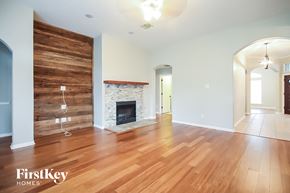 Bacliff house for rent - a living room with a fireplace and wooden floors