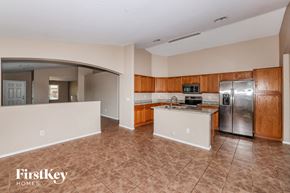 Avondale house for rent - an empty kitchen with stainless steel appliances and wooden cabinets