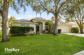 Valrico house for rent - a home with a lawn and trees in front of it
