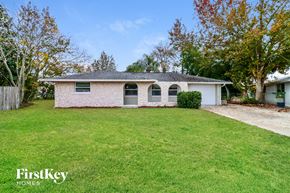Port Richey house for rent - a small brick house with a lawn and a driveway