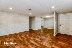 Port Richey house for rent - the living room and dining room with wood flooring and a white door