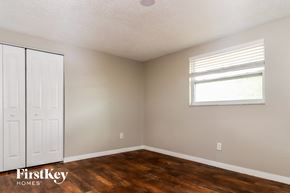 Port Richey house for rent - a bedroom with wood floors and a window and a white closet