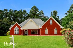 Loganville house for rent - a red house with white trim on a green lawn
