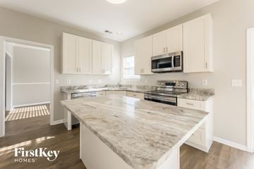 Goose Creek house for rent - a kitchen with white cabinets and a marble counter top