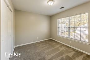 Goose Creek house for rent - a bedroom with a large window and a carpeted floor